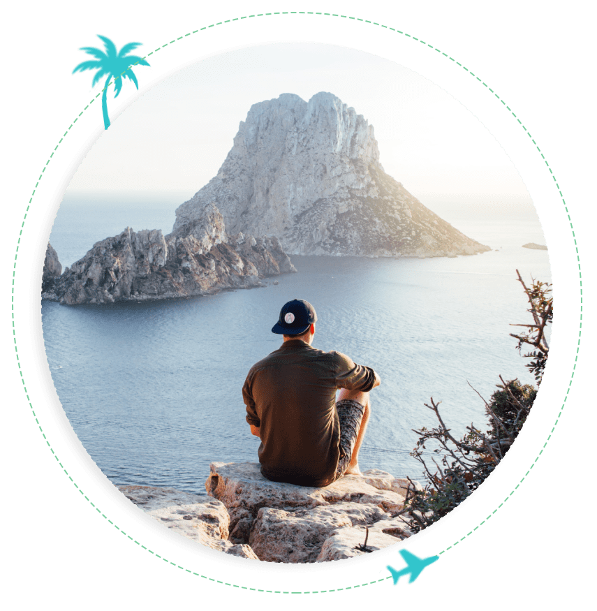 A man sitting on top of a rock near the ocean.